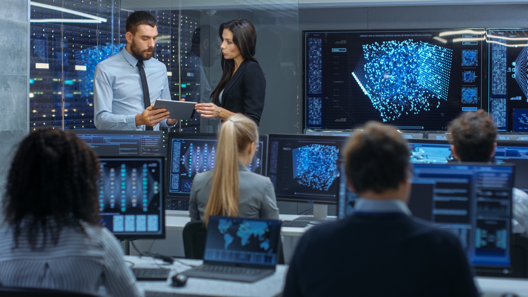 Head of the Department and Project Manager Discuss Work Process Using Data on Tablet Computer. Multi-Ethnic Team Builds Neural Network With Integrated Machine Learning.